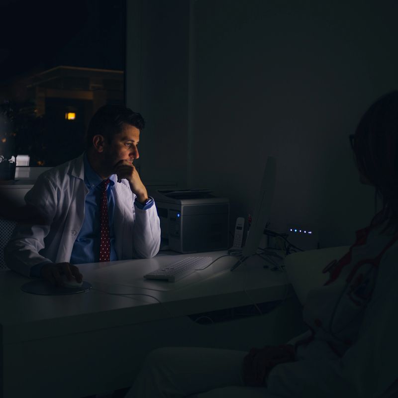 Doctors work at the office at night on a pc ( computer )