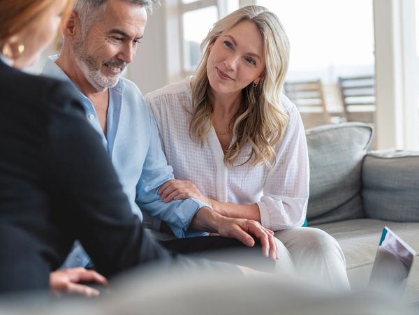 Mature couple consulting with a professional in a cozy living room.