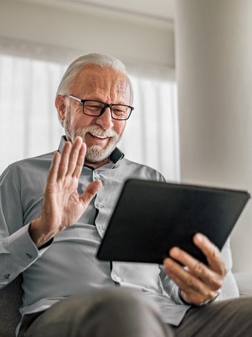 happy senior connecting with loved ones on a video call on a smart device