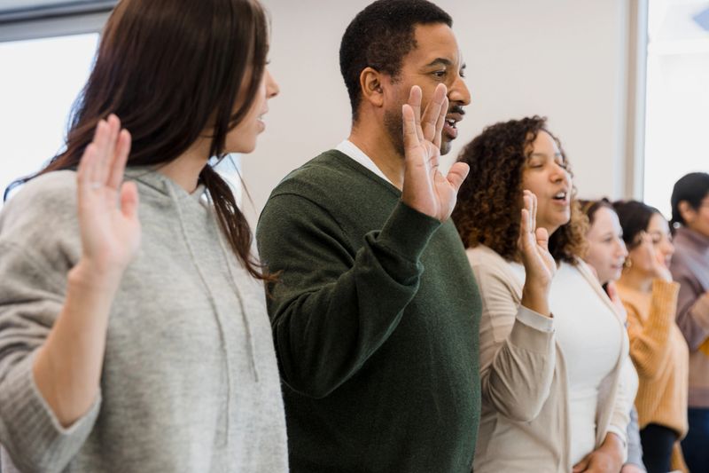 The class raises their hands to recite the Pledge.