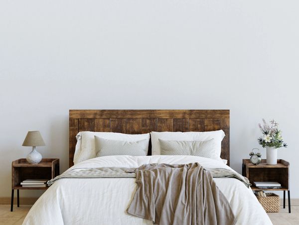 Modern bedroom with wooden bed and neutral bedding.
