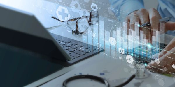 Person uses a calculator with medical icons and a tablet nearby.