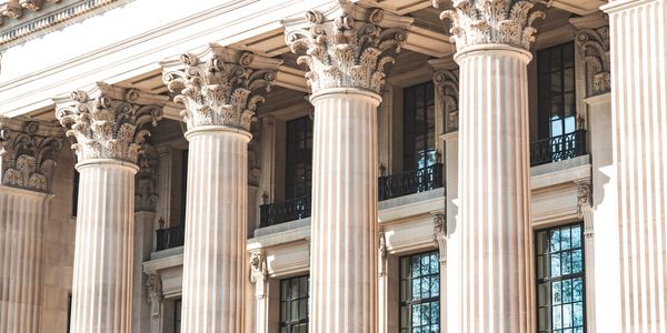 Classical building facade with ornate Corinthian columns and large windows.