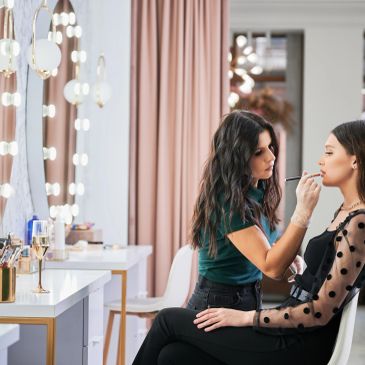 Artista aplicando maquillaje a una mujer en estudio.