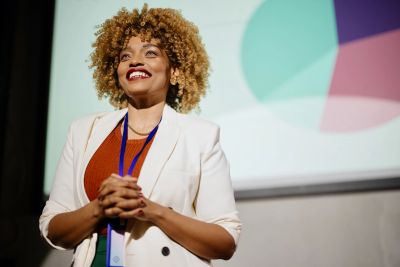 Femme souriante donnant une présentation professionnelle.