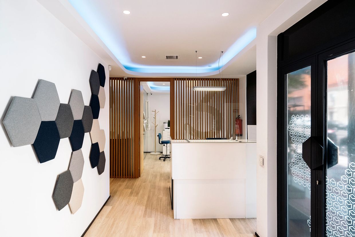 Modern office lobby with geometric wall art and wooden paneling.