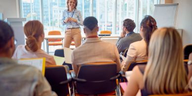Woman giving a presentation to a seated audience.
