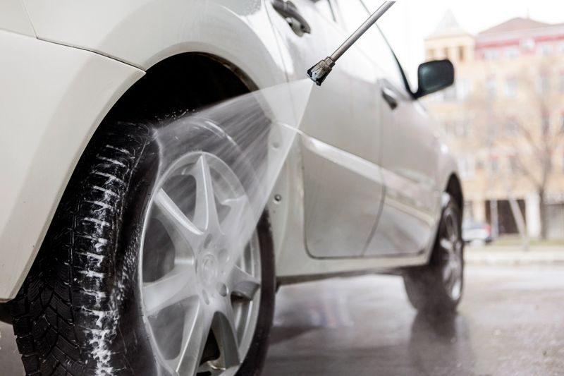 Man washes the car with a hose