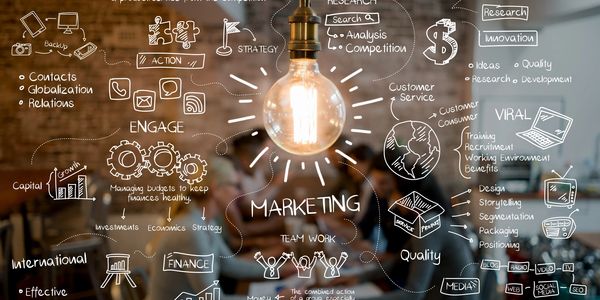 A glowing light bulb with marketing strategy doodles around it.