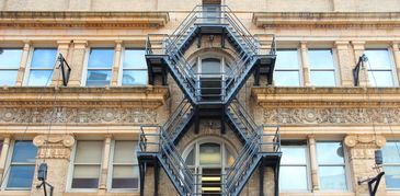 A fire escape on the facade of a decorated building.