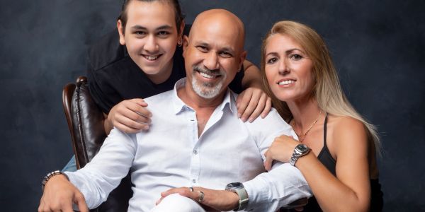 Smiling family portrait with three members.