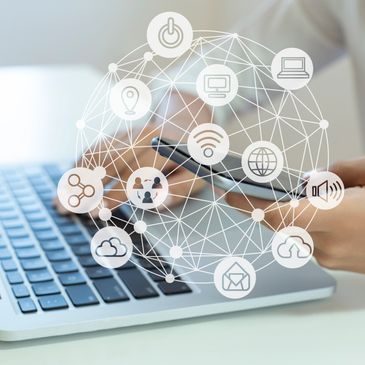 Person using smartphone and laptop with digital network icons overlay.