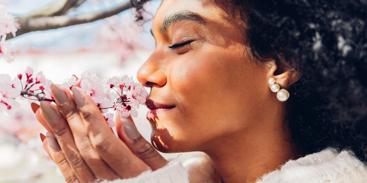 Woman enjoying the scent of cherry blossoms.