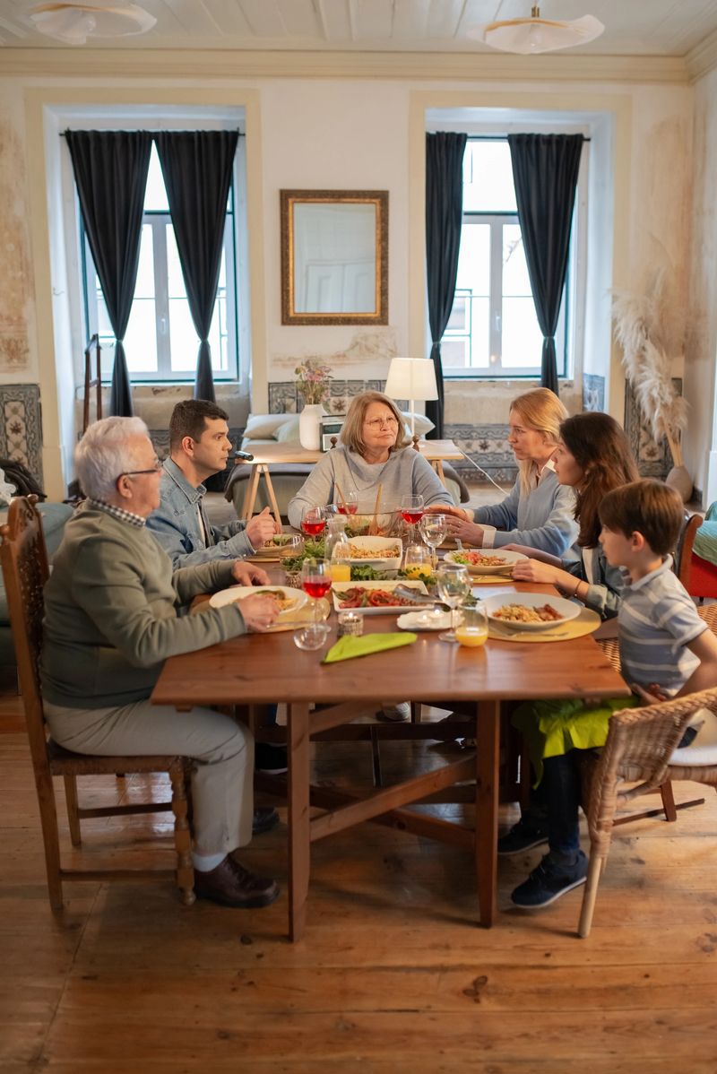 Multigenerational family having dinner together at home. Married couple sitting at table with children and grandparents and talking. Family party concept