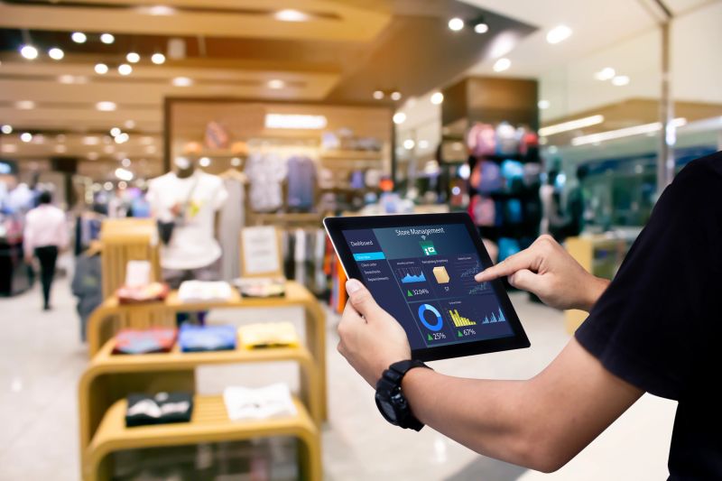 Manager using digital tablet on blurred store as background