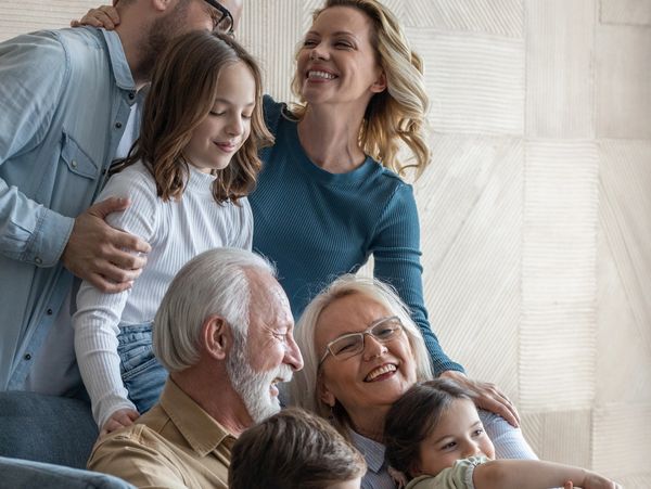 A joyful multi-generation family sharing a warm moment together knowing their financial future is secure.