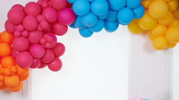Colorful balloon arch with pink, blue, yellow, and orange balloons.