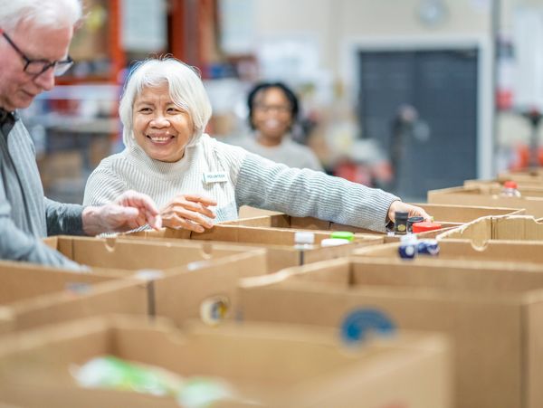 Volunteers sorting items in boxes at a community center.