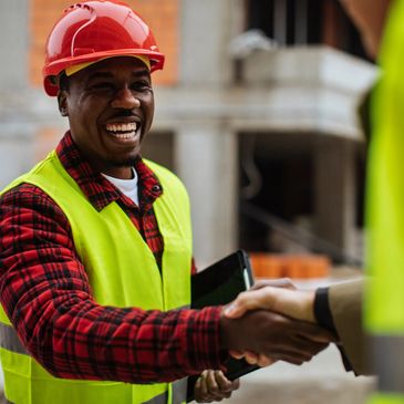 Construction worker smiling and shaking hands.