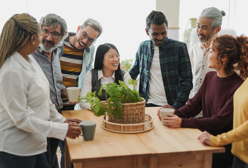 Group of multiracial people drinking coffee together indoor - Multi generational friends concept