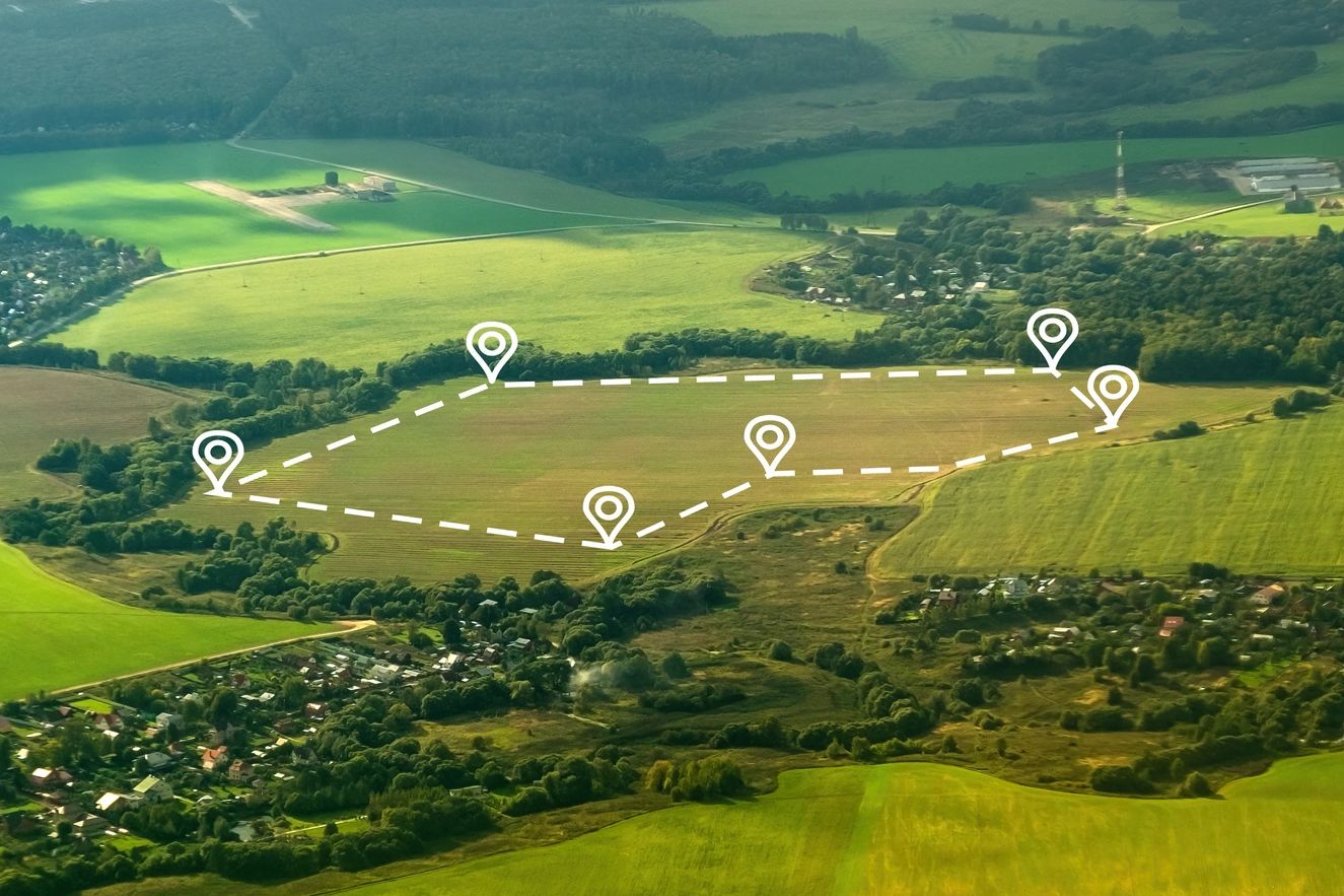 Aerial view of farmland with marked boundary points connected by dashed lines.