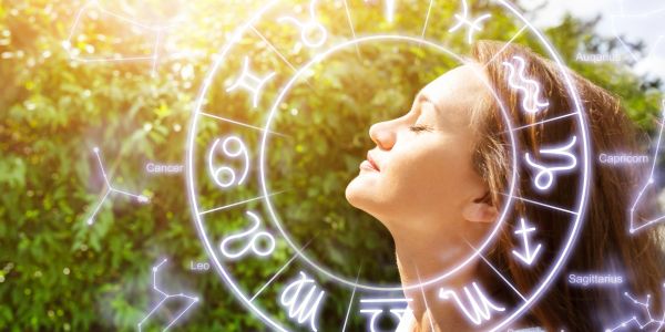 Woman enjoying sunlight with zodiac signs overlay.