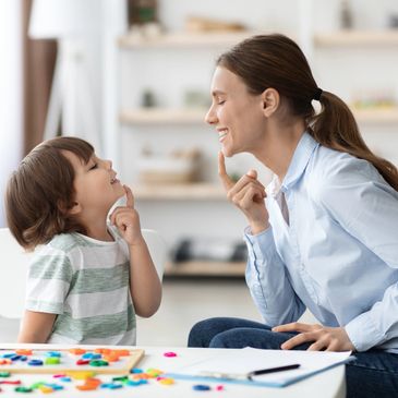 Mother and child smiling and learning together at home.