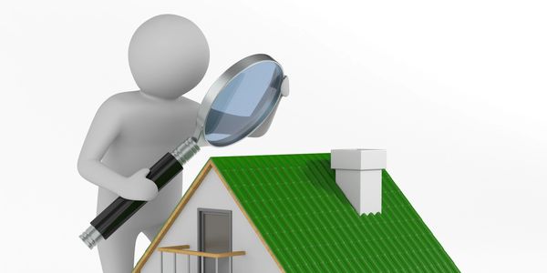 Figure inspecting a house with a magnifying glass.