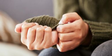 Person gripping their hands with anxiety