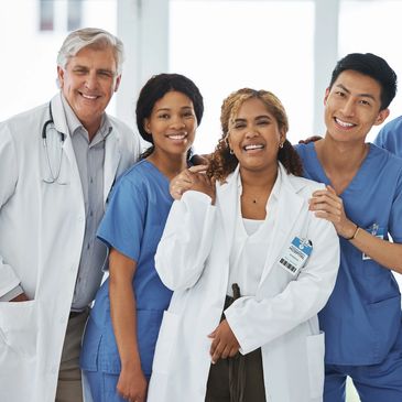 A diverse group of smiling healthcare professionals posing together in a hospital.