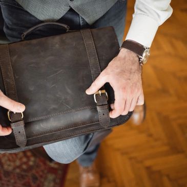 Man holding a brown leather briefcase.
