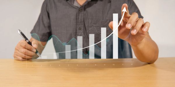 Person showing rising bar graph with upward arrow.