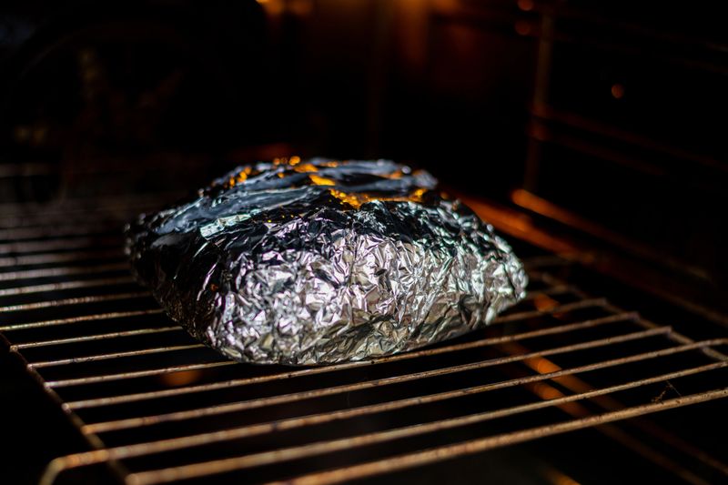 Meat in foil in the oven. Cooking, roasting pork.