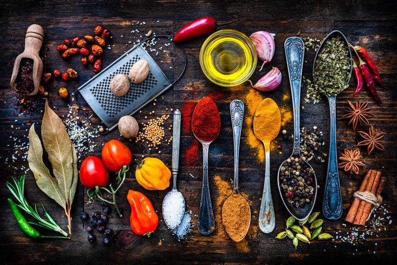 Spices, herbs and vegetables shot from above on rustic dark table. High resolution 42Mp studio digital capture taken with SONY A7rII and Zeiss Batis 40mm F2.0 CF lens