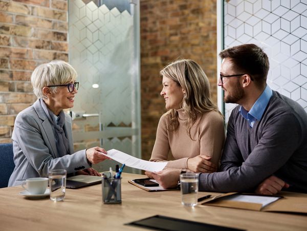 A couple meeting with a professional at a desk.