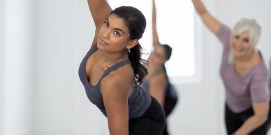 Women practicing yoga in a bright studio, focusing on balance and flexibility.