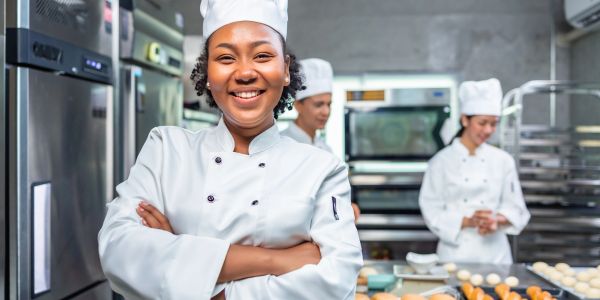 Smiling female chef in a bakery kitchen.