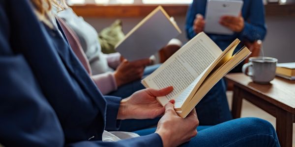 People sitting and reading books together in a cozy setting.