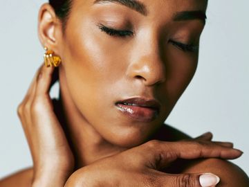 Close-up portrait of a woman with eyes closed and gold earrings.