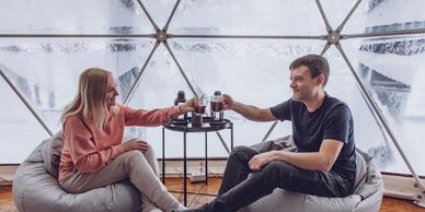 Couple relaxing inside a cozy glamping dome at Firefly Forest Campground in Pembine, WI