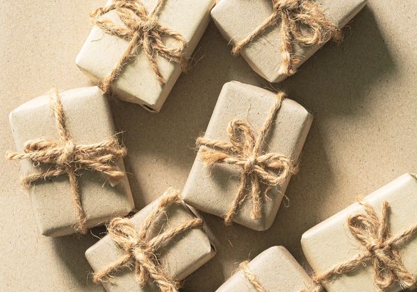 Several small gifts wrapped in plain paper and tied with rustic twine bows.