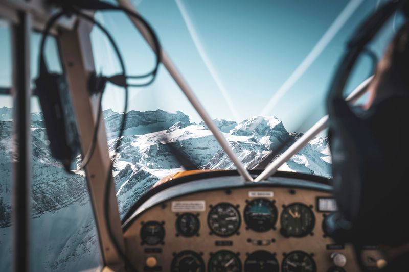 Cockpit view of a historic airplane flying into the mountains