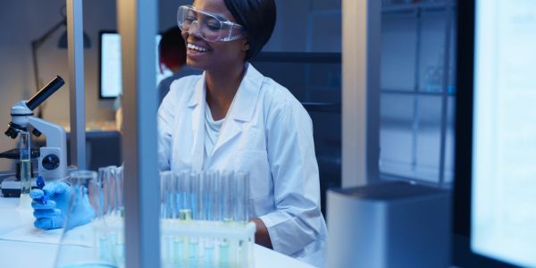 Scientifique souriante travaillant dans un laboratoire moderne.