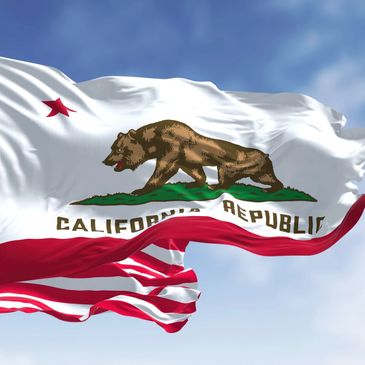California state flag waving against a clear blue sky.