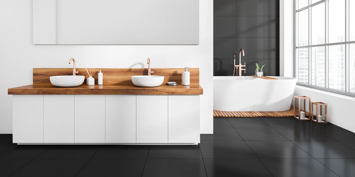 Modern bathroom with dual sinks and a freestanding tub by large windows.