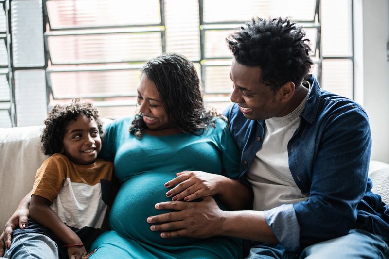 Father and pregnant mother with son at home