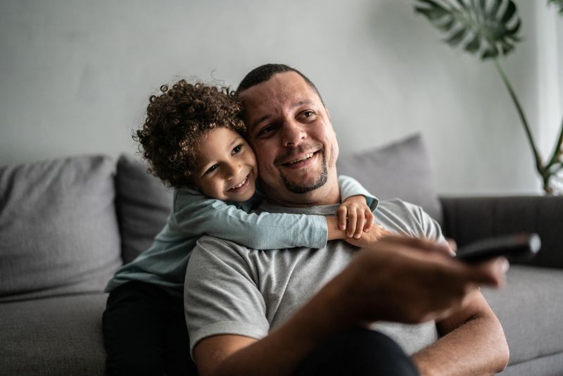 Father and son watching TV at home