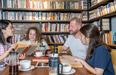 Group of friends reading books in a cozy bookstore.