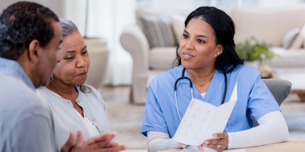 Nurse discussing care with elderly couple.
