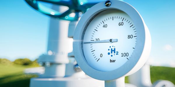 Close-up of a hydrogen pressure gauge on industrial equipment.
